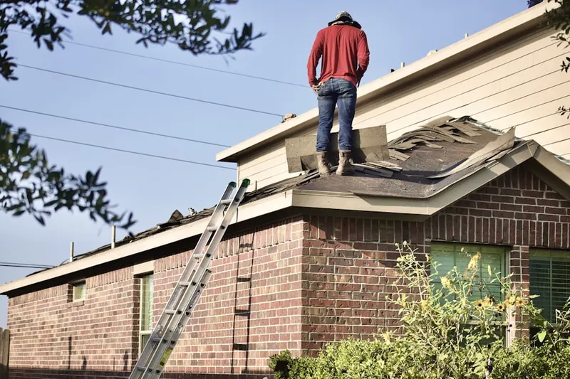 Professional roofer working on a residential roof in Fort Lee